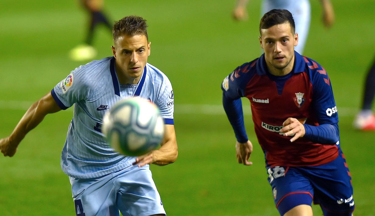 Bek Atletico Madrid, Santiago Arias, berebut bola dengan penyerang Osasuna, Jose Arnaiz, pada laga lanjutan La Liga pekan ke-29 di Stadion El Sadar, Pamplona, Kamis (18/6/2020) dini hari WIB. Atletico menang telak 5-0 atas Osasuna. (AFP/Ander Gillenea)