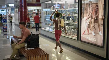 Anggota suku Kariri berjalan di sebuah mal di Brasilia (26/8/2021).  Ia masuk ke dalam mal saat para pengunjuk rasa suku pribumi lainnya berkumpul di ibu kota Brasil saat Mahkamah Agung bersiap untuk menangani kasus yang dapat menghilangkan keberatan di tanah leluhur mereka. (AFP/Carl De Souza)