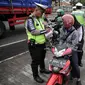 Anggota Polantas menilang pengendara motor yang melintas di jalur cepat di jalan Letjen Suprapto, Jakarta, Selasa (7/11). Sejauh ini, total ada 55.457 kendaraan yang telah ditilang oleh polisi. (Liputan6.com/Faizal Fanani)