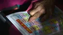 Nenek Ramabai Khandakre (69) membaca buku selama mengikuti kegiatan di Sekolah Aajibaichi Shaala, Desa Fangane, India, pada 1 Maret 2017. (AFP Photo / Indranil Mukherjee)