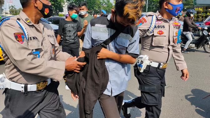 Momen ketika polisi di Palembang mengamankan salah satu pendemo di tengah aksi demonstrasi.