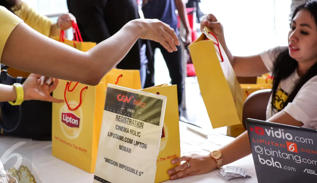 Panitia menyiapkan souvenir untuk para Cinemaholic di Blitz Megaplex, Jakarta, Sabtu (8/8/2015). Cinemaholic bersama Liputan6.com gelar nonton bareng Mision Impossible Rogue Nation (Liputan6.com/Helmi Afandi)