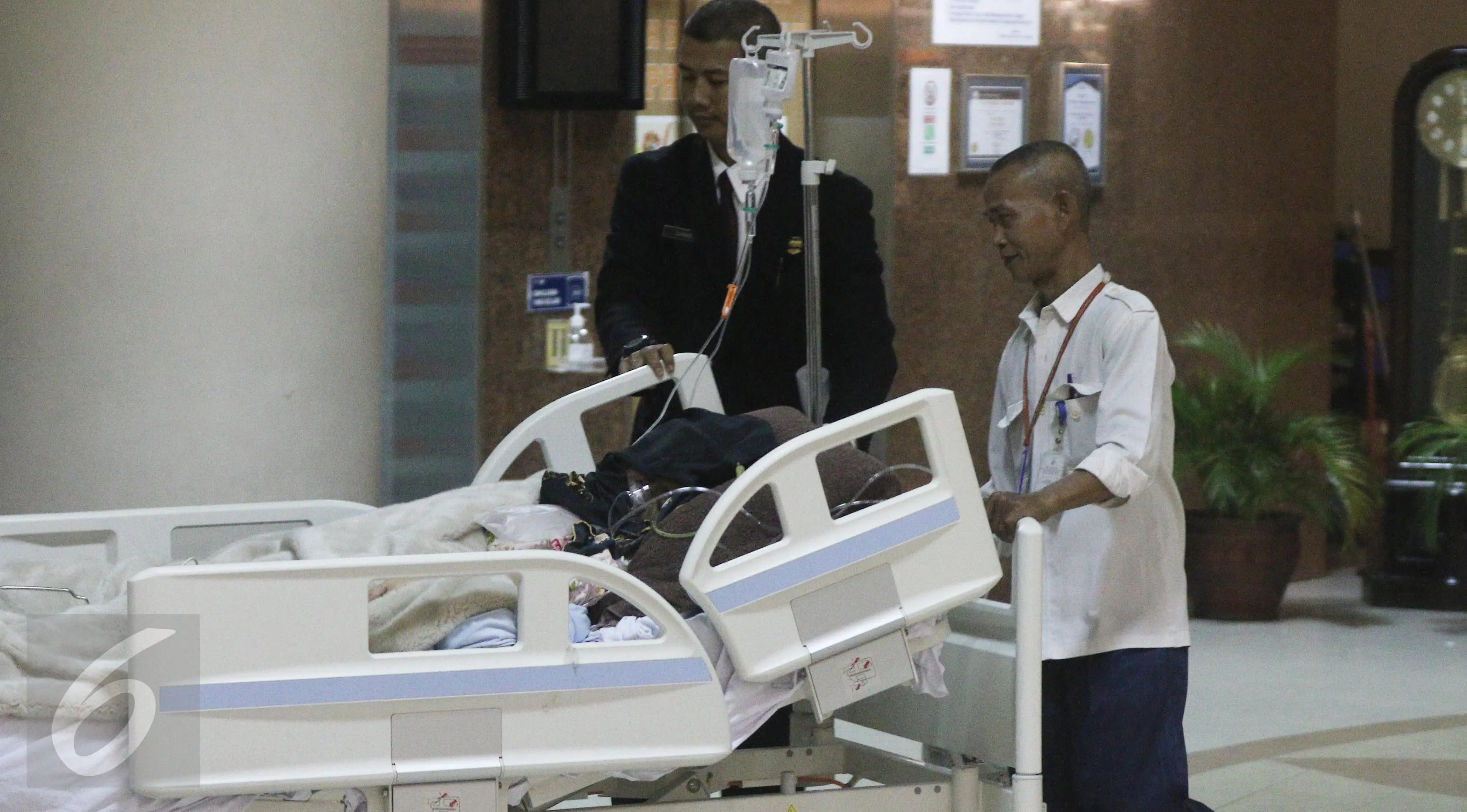Petugas membawa Julia Perez alias Jupe ke ruang perawatan usai menjalani cuci darah di RSCM, Jakarta (21/4). Pelantun lagu Belah Duren tersebut terlihat terbaring lemah dengan kondisi kepala tertutup kain hitam. (Liputan6.com/Herman Zakharia)