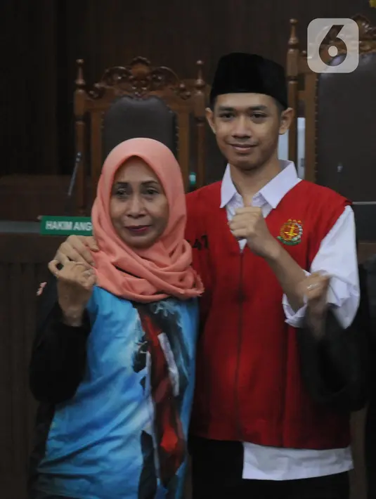 Dede Luthfi Alfiandi, pembawa bendera Merah Putih saat aksi siswa SMK September lalu, bersama ibunya di Pengadilan Negeri Jakarta Pusat, Kamis (12/12/2019). Luthfi didakwa melanggar Pasal 212 KUHP juncto Pasal 214 KUHP atau Pasal 217 ayat 1 KUHP atau 218 KUHP. (Liputan6.com/Helmi Fithriansyah)