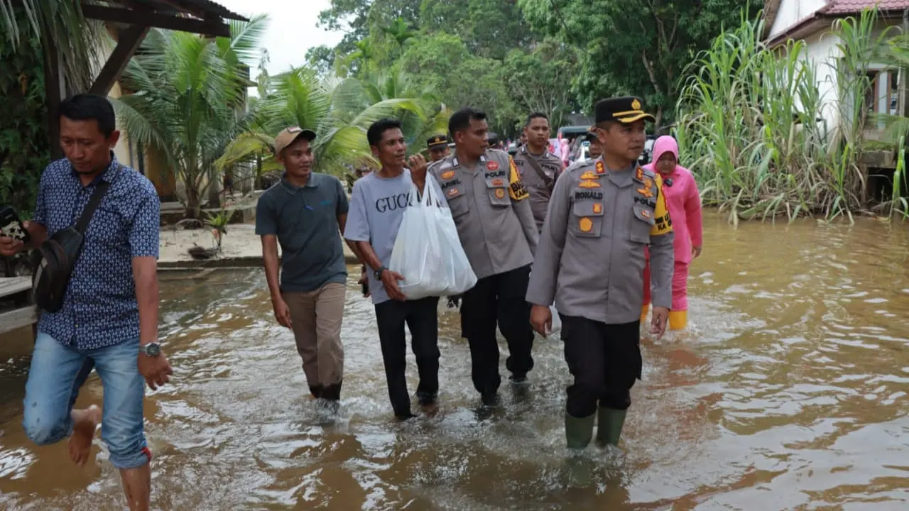 Kapolres Kampar AKBP Ronald Sumaja datang ke Desa Buluh Cina memberikan bantuan sembako dan berbincang dengan warga terkait situasi keamanan di desa. (Liputan6.com/ ist)
