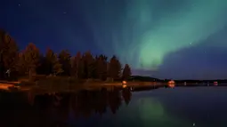 Langit desa Erikslund  berhias cahaya aurora borealis, di Swedia, (23/8). Fenomena langka ini muncul dari tabrakan antara partikel gas di atmosfer bumi dengan partikel bermuatan dari matahari. (AFP PHOTO/ JONATHAN NACKSTRAND)