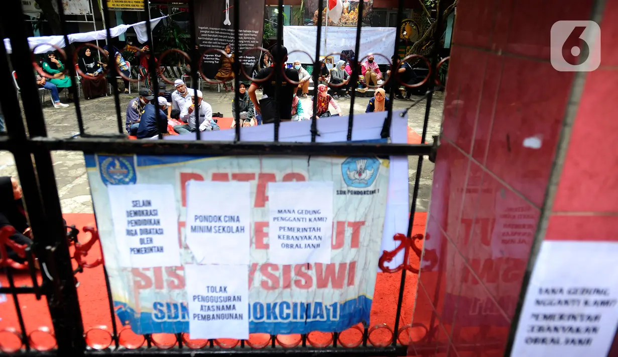 Orangtua murid bertahan dalam gedung saat pasukan Satpol PP hendak mengosongkan bangunan SDN Pondok Cina 1, Depok, Jawa Barat, Minggu (11/12/2022). Ketegangan dan adu argumentasi antara petugas dan sejumlah orang yang mengaku sebagai kuasa hukum orang tua siswa pun tak terhindarkan. (merdeka.com/Arie Basuki)