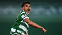 Gelandang Sporting Lisbon, Matheus Nunes melakukan selebrasi usai mencetak gol ke gawang Benfica di masa injury time dalam laga lanjutan Liga Portugal 2020/21 di Jose Avalade Stadium, Lisbon, Senin (1/2/20201). Sporting menang 1-0 atas Benfica. (AFP/Patricia De Melo Moreira)