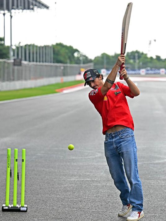 Pembalap Italia dari Ducati Lenovo Team, Francesco Bagnaia, bermain kriket di lintasan menjelang Grand Prix MotoGP India di Sirkuit Internasional Buddh, Greater Noida, di pinggiran New Delhi, pada 21 September 2023. (Money SHARMA/AFP)