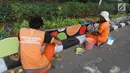 Petugas PPSU Gondangdia mengecat pembatas jalan dengan warna-warni Asian Games di kawasan Menteng, Jakarta, Kamis (12/7). Cat lukisan dinding beraneka gambar dan bentuk untuk menyambut HUT kemerdekaan RI dan Asian Games 2018. (Liputan6.com/Arya Manggala)