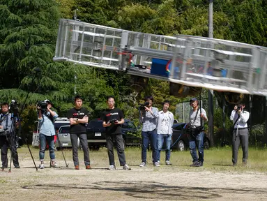 Pemimpin proyek Cartivator, Tsubasa Nakamura (ketiga kiri) menyaksikan uji coba model mobil terbang di kota Toyota, Jepang (3/6). Sebuah perusahaan start up yang disokong oleh Toyota menguji coba prototype dari model mobil terbang. (AP Photo/Koji Ueda)