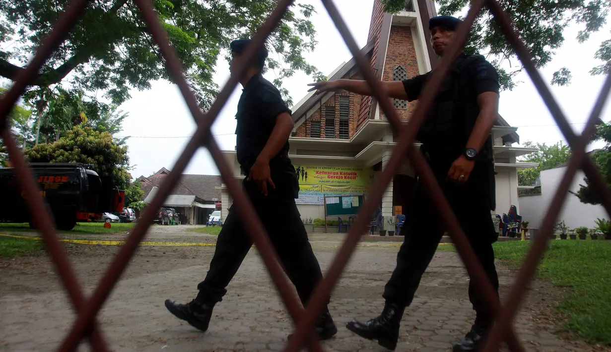 Personel Brimob berjaga di halaman Gereja Katolik Santo Yosep pasca teror bom di lokasi tersebut, Medan, Sumut, Minggu (28/8). Polisi menangkap seorang pria yang mencoba melakukan bom bunuh diri di dalam Gereja Katolik tersebut. (AFP PHOTO/HAKIM Rangkuti)