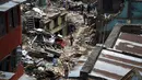 Sejumlah warga berjalan di reruntuhan puing bangunan pasagempa susulan berkekuatan 7,3 SR melanda Sankhu, Nepal, Selasa (12/5/2015). Sebelumnya, luka atas gempa dahsyat yang terjadi 25 April lalu di Nepal masih belum terobati. (REUTERS/Navesh Chitrakar)