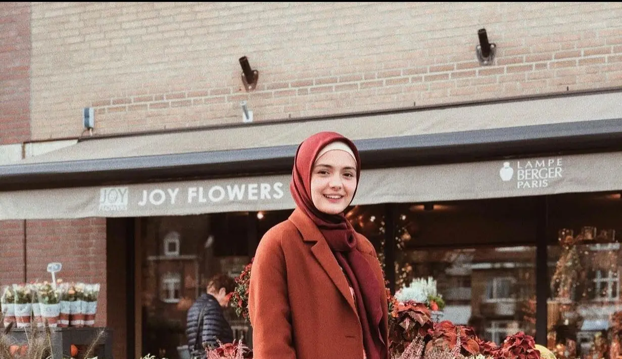 Apabila kamu berhijab, maka long coat dan hijab berwarna senada serta dipadu padankan dengan ankle boots merupakan outfit yang nyaman saat kamu sedang mengunjungi Paris. (instagram/amandarawles)