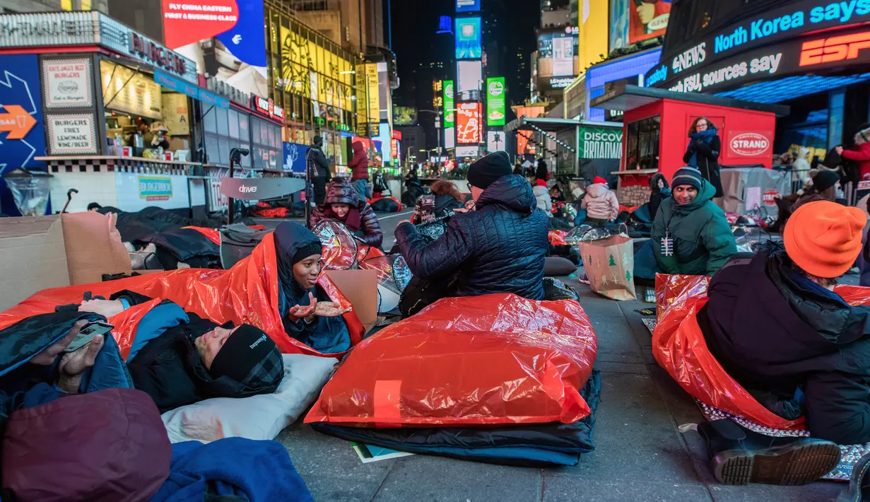 Orang-orang menghabiskan malam dengan tidur di area terbuka dalam acara World's Big Sleep Out di Times Square, New York, 7 Desember 2019. Aksi di beberapa kota besar dunia ini sebagai bagian dari upaya penggalangan dana untuk membantu para tunawisma di banyak negara. (Charles Sykes/Invision/AP)