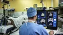 Seorang ahli bedah duduk di depan layar mengendalikan robot untuk operasi prostat dengan pencitraan USG (10/4/2014) (AFP Photo/Jeff Pachoud).