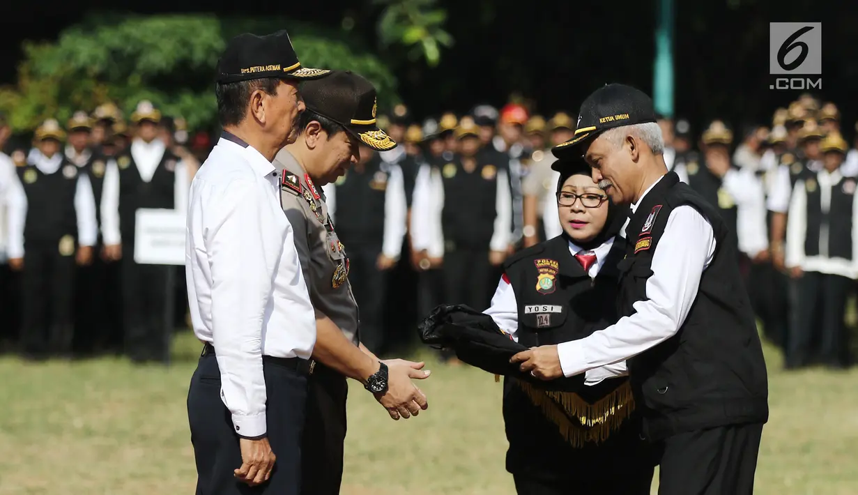 Ketua Pokdarkamtibmas Polda Metro Jaya Heru Riyadi memberikan rompi ke Wakapolda Metro Jaya, Brigjen Pol Purwadi saat apel besar di lapangan Sabhara Mapolda Metro Jaya, Jakarta, Sabtu (12/5). (Liputan6.com/Herman Zakharia)