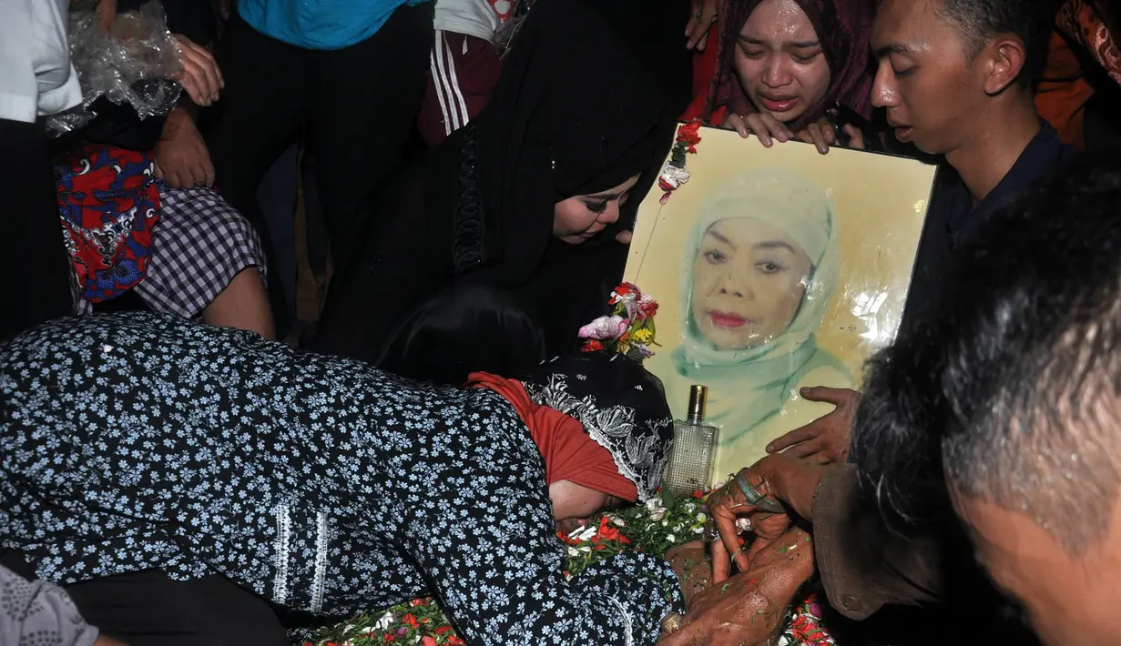 Sang anak pun seolah tak mau beranjak dari makam Mpok Nori (Foto: Muhammad Akrom Sukarya)