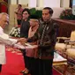 Presiden Jokowi didampingi Wakil Presiden Ma'ruf Amin dan Menkeu Sri Mulyani menyerahkan Daftar Isian Pelaksanaan Anggaran (DIPA) dan Daftar Alokasi Transfer Daerah serta Dana Desa Tahun 2020 kepad Menteri PUPR Basuki Hadimuljono di Istana Negara, Kamis (14/11/2019). (Liputan6.com/Angga Yuniar)