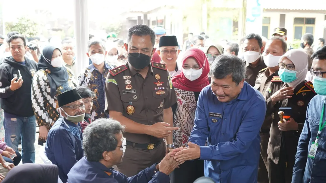Kepala Kejaksaan Tinggi (Kajati) Jabar, Asep Nana Mulyana bersama Bupati Garut Rudy Gunawan tengah menyapa salah satu pasien katarak selepas operasi karatak gratis kepada masyarakat. (Liputan6.com/Jayadi Supriadin)