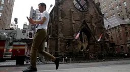 Pejalan kaki melintas di depan Gereja Katedral Ortodoks Serbia dari Saint Sava di Manhattan, New York, Senin (2/5). Gereja berusia 160 tahun itu dilalap api pada Minggu, 1 Mei 2016, beberapa saat setelah umat merayakan Paskah. (REUTERS/Brendan McDermid)
