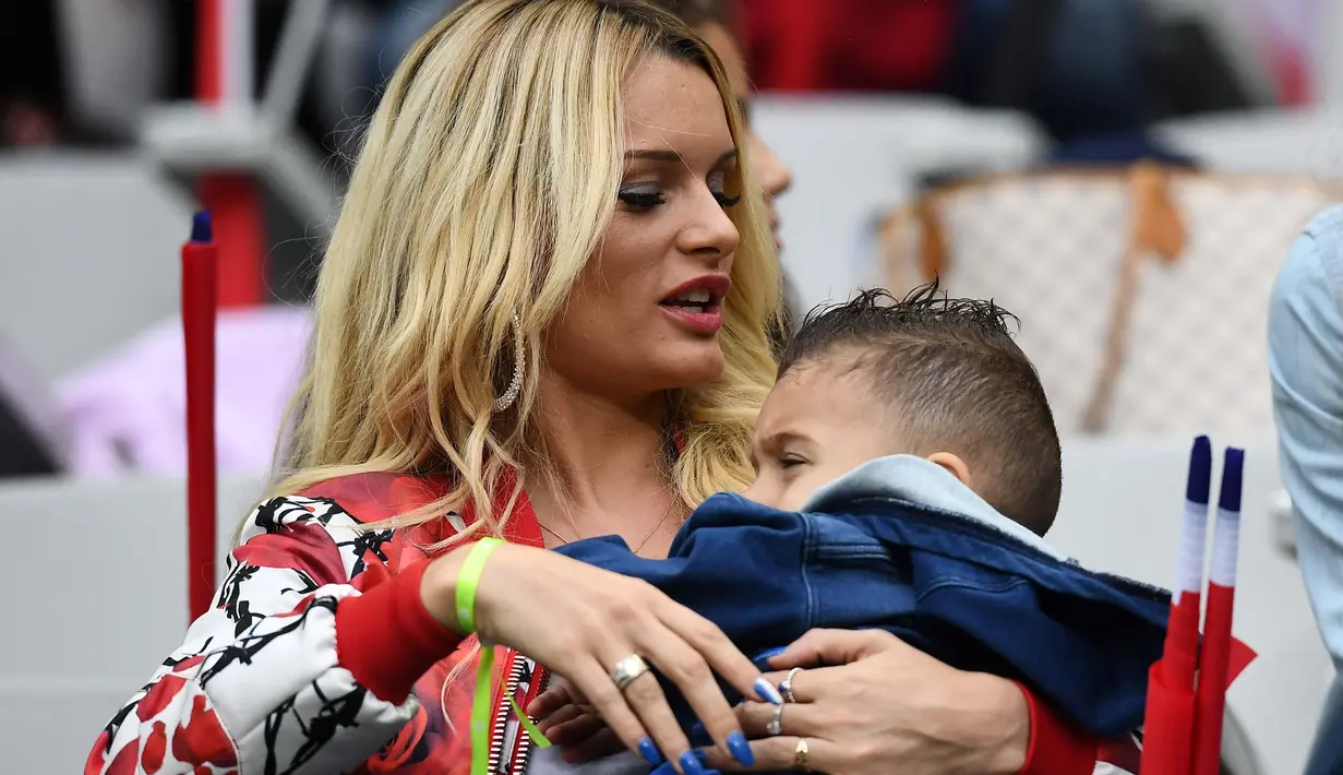 Ludivine Payet menggendong anaknya saat menonton suaminya Dimitri Payet bersama tim Prancis melawan Islandia pada perempat final Piala Eropa 2016 di Stade de France, Saint-Denis, Paris. (4/7/2016) dini hari WIB. (AFP/Franck Fife)