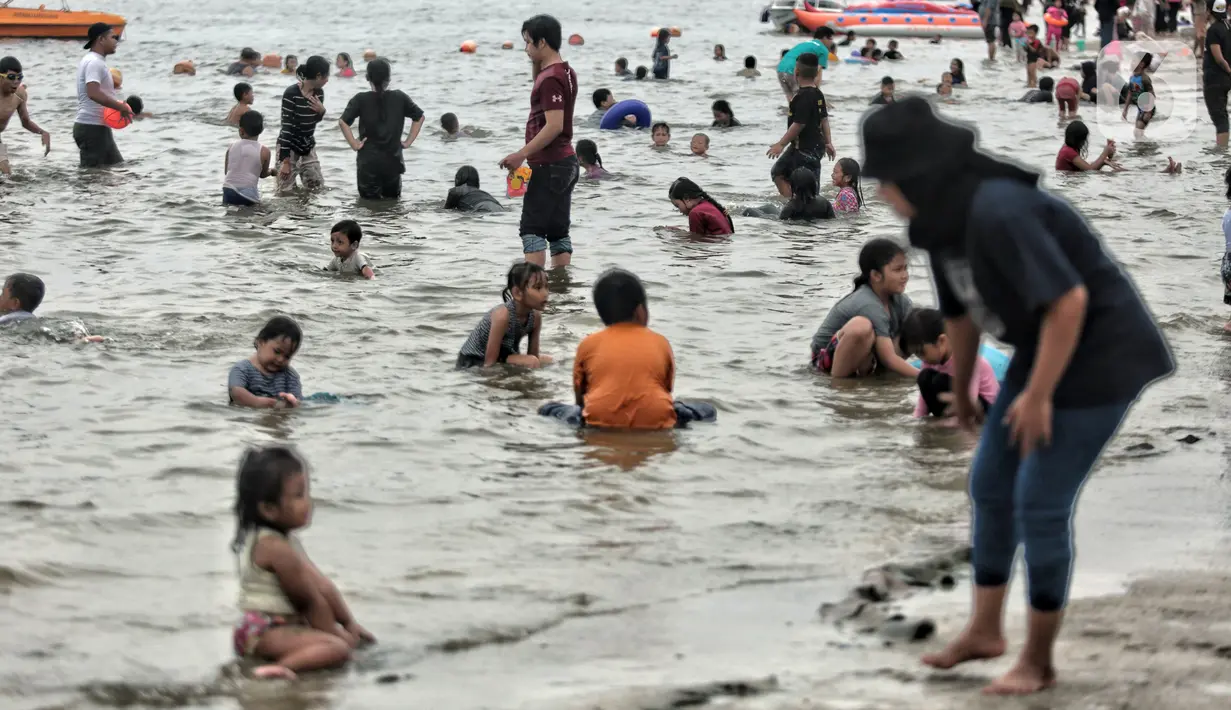 Wisatawan memadati Pantai Ancol saat mengisi libur Natal, Jakarta, Minggu (25/12/2022). Kepala Komunikasi PT Pembangunan Jaya Ancol Ariyadi Eko Nugroho mengungkapkan per hari ini jumlah wisatawan di Taman Impian Jaya Ancol tembus 40.000, angka tersebut meningkat dua kali lipat dibanding libur hari biasa maupun Natal tahun 2021. (merdeka.com/Iqbal S. Nugroho)