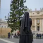 Seorang biarawati mengamati pemasangan pohon cemara berusia 113 tahun dan setinggi 28 meter di Lapangan Santo Petrus, untuk dijadikan pohon Natal, di Vatikan, Selasa (23/11/2021). Hadiah dari kota Andalo di timur laut Italia itu akan menyala pada 10 Desember mendatang. (AP Photo/Andrew Medichini)