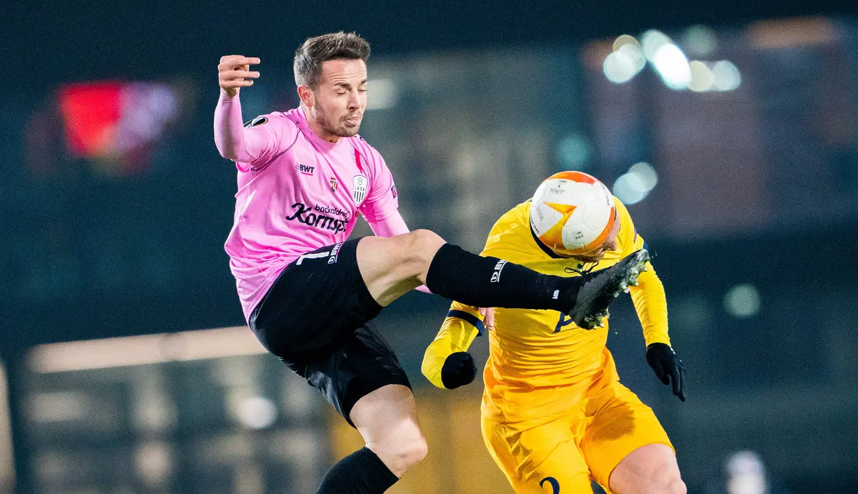 Bek Tottenham Hotspur, Matt Doherty, berebut bola dengan gelandang LASK, Rene Renner, pada laga lanjutan Liga Europa di Linzer Stadium, Jumat (4/12/2020) dini hari WIB. Tottenham bermain imbang 3-3 lawan LASK. (AFP/Georg Hochmuth/APA)
