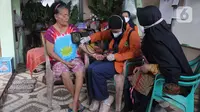 Petugas kesehatan melakukan pemeriksaan kepada lansia saat vaksinasi booster COVID-19 dari rumah ke rumah di Poris Plawad, Tangerang, Jumat (21/1/2022). Pelaksanaan vaksinasi dari rumah ke rumah untuk memudahkan para lansia mendapatkan vaksin booster COVID-19. (merdeka.com/Arie Basuki)