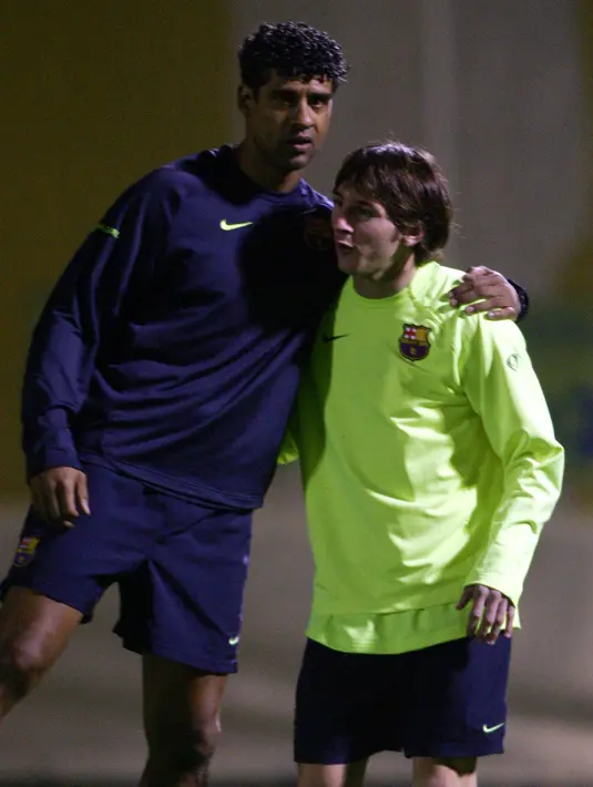 Lionel Messi berbincang dengan pelatih Barcelona Frank Rijkaard selama sesi latihan jelang melawan Real Madrid pada pertandingan Liga Spanyol di Barcelona pada 17 November 2005. (AFP/Lluis Gene)