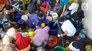 Warga berebut air bersih yang didistribusikan oleh Relawan Gerak Bareng di Desa Karihkil, Ciseeng, Bogor, Minggu (10/09/2023). (merdeka.com/Arie Basuki)