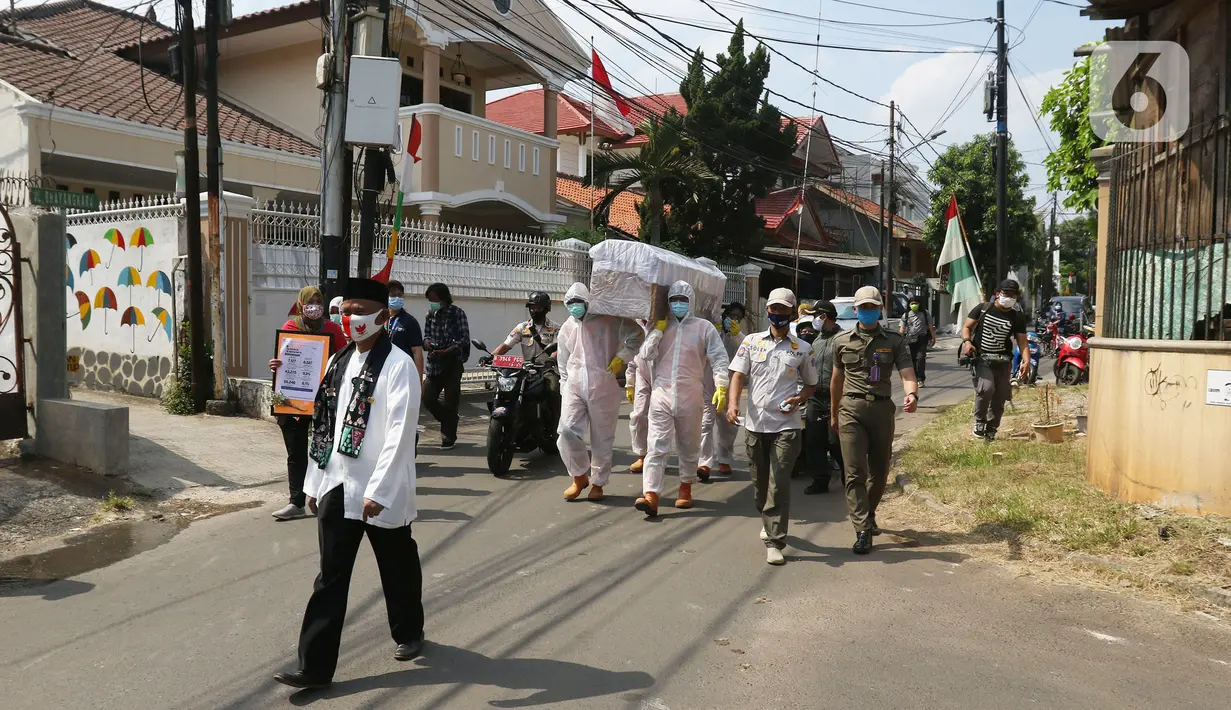Petugas gabungan dari Kecamatan Cilandak mengarak instalasi peti mati jenazah Covid-19 di kawasan perumahan Fatmawati, Jakarta, Jumat (28/8/2020). Sosialisasi tersebut dilakukan untuk memberikan peringatan kepada warga akan bahaya penularan virus Covid-19. (Liputan6.com/Herman Zakharia)