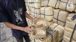 Pedagang menunjukkan besek dari anyaman bambu di Pasar Jatinegara, Jakarta, Kamis (1/7/2021). Harga satu besek dibandrol mulai dari Rp3.000 hingga Rp6.000 tergantung ukuran besek. (Liputan6.com/Faizal Fanani)