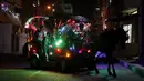 Anak-anak menaiki kereta kuda yang dihiasi lampu warna-warni saat merayakan puasa bulan suci Ramadhan di sepanjang gang di Kota Gaza, Palestina, Selasa (20/4/2021). Umat muslim dunia melangsungkan puasa selama satu bulan penuh pada bulan suci Ramadhan. (AP Photo/Adel Hana)