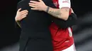 Pelatih Arsenal, Mikel Arteta memeluk gelandang Granit Xhaka usai pertandingan melawan Chelsea pada lanjutan Liga Inggris di Stadion Emirates di London, Minggu (27/12/2020). Dengan tambahan tiga poin, Arsenal berada di posisi ke 15 klasemen. (AFP/Pool/Adrian Dennis)