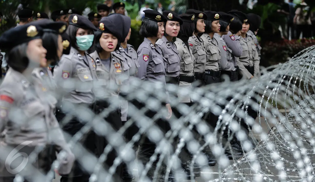 Sejumlah polisi wanita (Polwan) berbaris di belakang kawat berduri yang terpasang di kawasan Jalan Merdeka Barat, Jumat (31/3). Para polwan dari Brimob Polda Metro Jaya tersebut dikerahkan dalam pengamanan aksi 31 Maret. (Liputan6.com/Faizal Fanani)