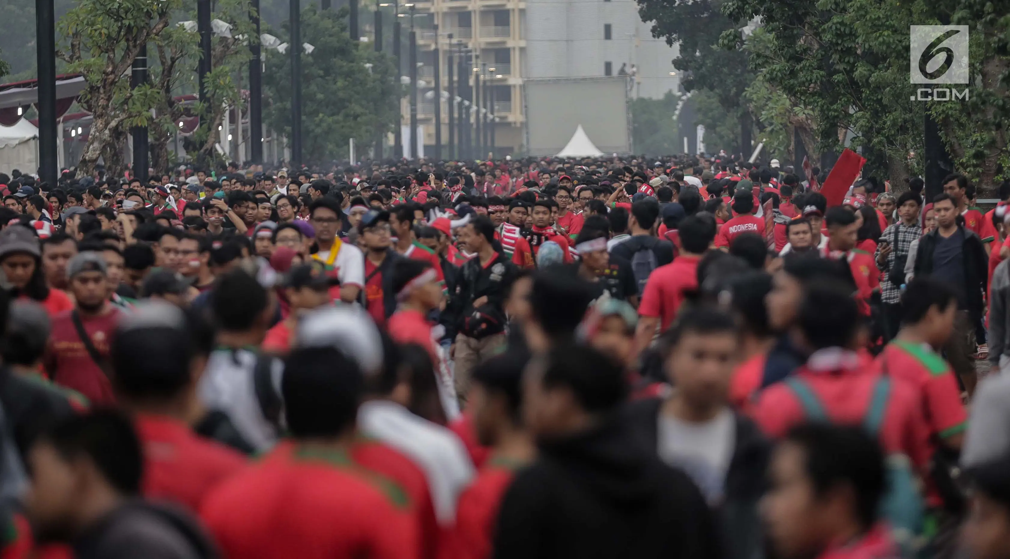 Ribuan suporter Timnas Indonesia beratribu merah putih mulai berdatangan di Stadion Gelora Bung Karno (GBK), Senayan, Jakarta, Minggu (14/1). Presiden Jokowi dijadwalkan bakal ikut menyaksikan pertandingan ini. (Liputan6/Faizal Fanani)