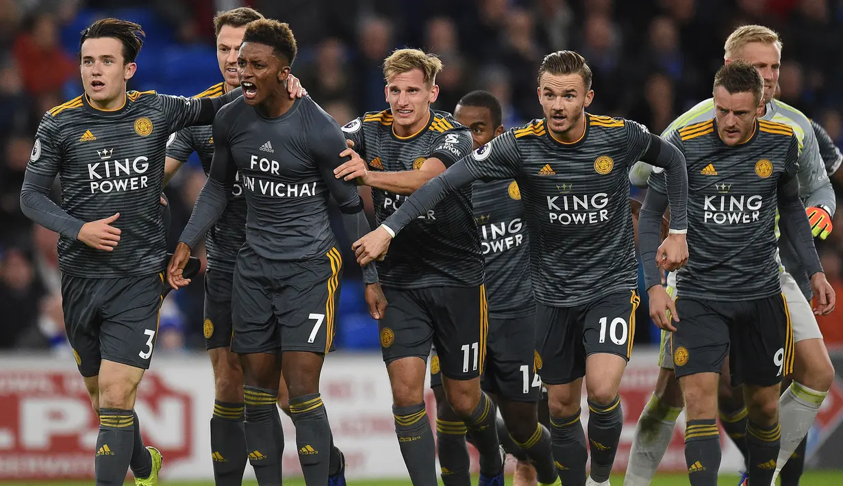 Gelandang Leicester, Demarai Gray, merayakan gol ke gawang Cardiff pada laga Premier League di Stadion Cardiff City, Wales, Sabtu (3/11). Selebrasi Gray memakai baju bertuliskan "For Vichai" untuk mengenang sang pemilik. (AFP/Oli Scarff)