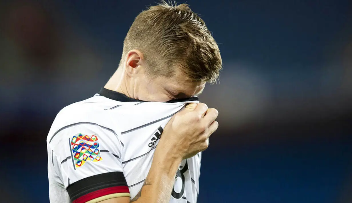 Pemain Jerman, Toni Kroos, menutup wajahnya usai gagal menaklukkan Swiss pada laga UEFA Nations League di Stadion St. Jakob-Park, Senin, (7/9/2020). Kedua tim bermain imbang 1-1. (Peter Klaunzer/Keystone via AP)