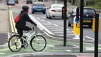 Seorang wanita mengendarai sepeda di jalur sepeda persimpangan CYCLOPS (Cycle Optimized Protected Signals) di wilayah selatan Manchester, Inggris (9/10/2020). Persimpangan CYCLOPS diluncurkan dengan desain unik yang memisahkan pejalan kaki dan pesepeda dari lalu lintas. (Xinhua/Jon Super)