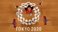 Foto yang diambil dengan kamera robot ini menunjukkan reaksi Windy Cantika Aisah dari Indonesia saat berlaga dalam kompetisi angkat besi 49kg putri pada Olimpiade Tokyo 2020 di Tokyo International Forum, Tokyo pada 24 Juli 2021. (AFP/Pool/Chris Graythen)