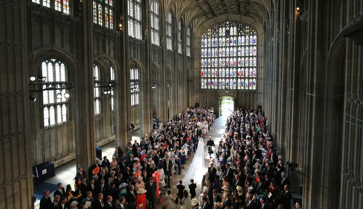 Pemandangan saat Pangeran Harry dan istri, Meghan Markle berjalan meninggalakan altar usai prosesi pernikahan mereka di Kastil Windsor, Inggris, Sabtu (19/5). (Danny Lawson/pool photo via AP)