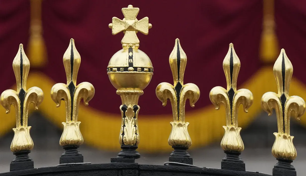 Ornamen emas terlihat di atas gerbang Istana Buckingham sebelum upacara penobatan Raja Charles III  di London, Sabtu (6/5/2023). (AP Photo/Frank Augstein)