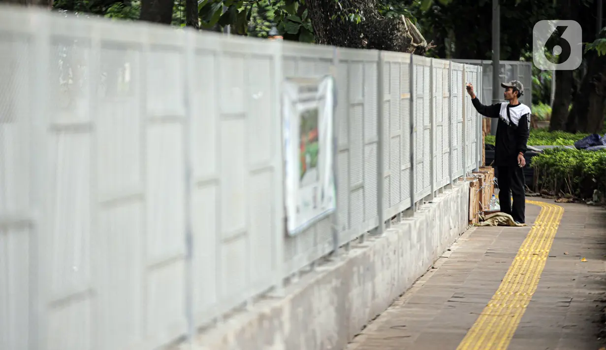 Pekerja melakukan pengecatan saat menyelesaikan pemasangan pagar yang mengelilingi area ruang terbuka hijau (RTH) Tebet Eco Park, Jakarta, Senin (12/12/2022). Pemasangan pagar tersebut membuat taman terkesan lebih rapih dan bagus. (Liputan6.com/Faizal Fanani)