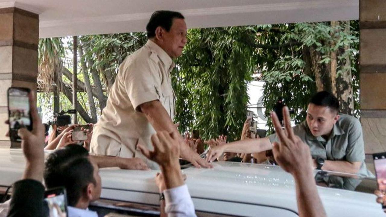 Ketua Umum Partai Gerindra Prabowo Subianto naik di atas mobilnya saat menyapa para relawan usai menghadiri acara peresmian rumah pemenangan relawan di Menteng, Jakarta, Selasa (15/8/2023).