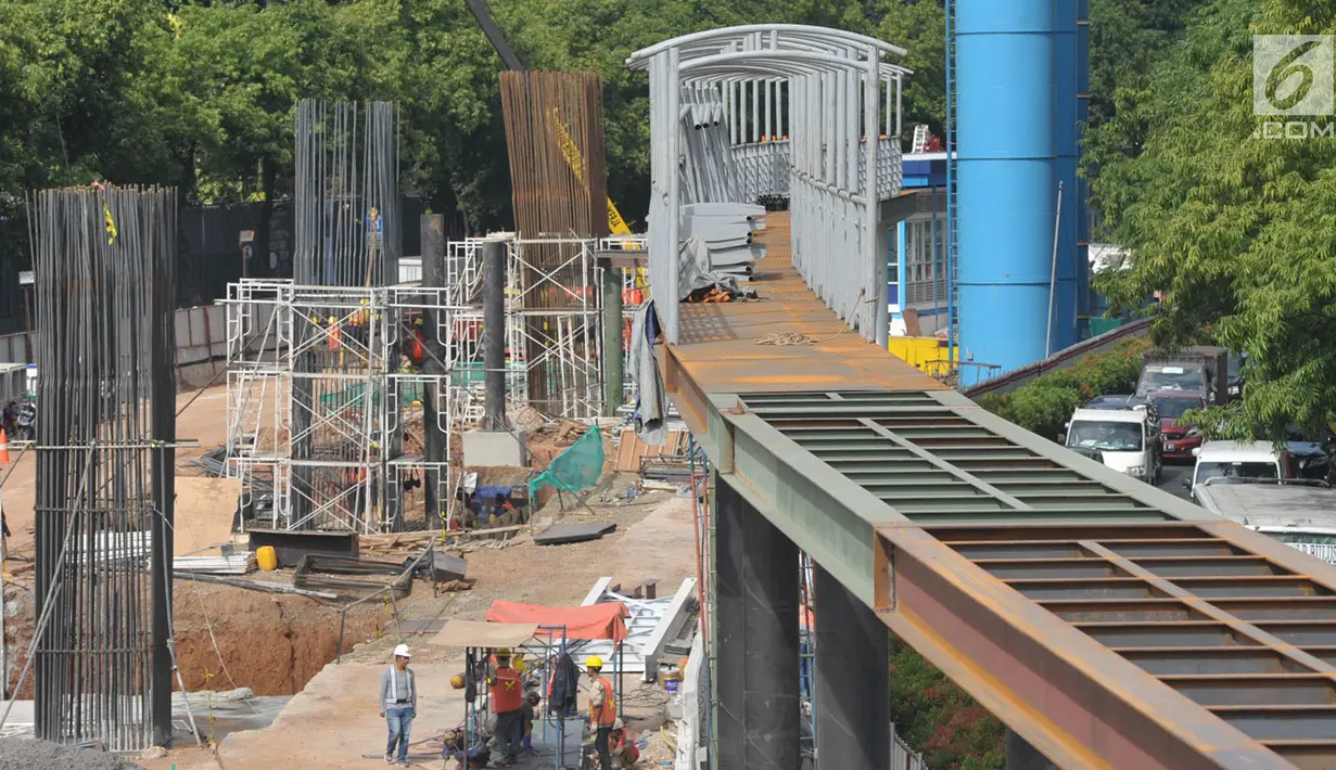 Sejumlah pekerja menyelesaikan pembuatan jembatan penyeberangan orang (JPO) di Halte Kuningan Timur, Jakarta, Selasa (9/1). Pembangunan tersebut sebagai akses menunju halte Transjakarta serta (Liputan6.com/Immanuel Antonius)