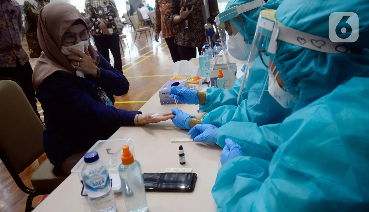 Petugas mengambil sampel darah Wakil Ketua KPK, Lili Pintauli Siregar saat rapid test COVID-19 di Gedung KPK, Jakarta, Kamis (4/6/2020). Rapid test itu diikuti sekitar 2.000 orang di lingkungan Komisi Pemberantasan Korupsi (KPK) menjelang kenormalan baru atau new normal. (merdeka.com/Dwi Narwoko)
