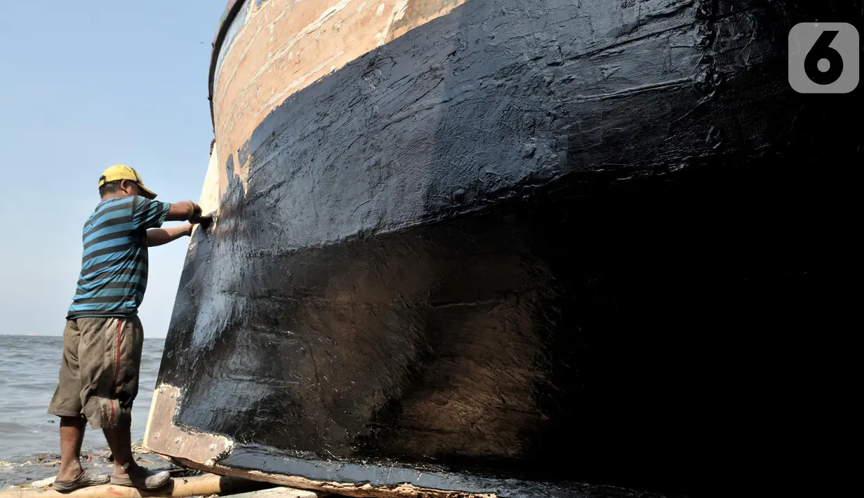 Pekerja menyelesaikan proses perbaikan kapal nelayan di pesisir Marunda, Jakarta, Selasa (22/10/2019). Untuk jasa perbaikan satu buah kapal biasanya dipatok dengan harga Rp 15 juta dalam waktu pengerjaan hingga sebulan. (merdeka.com/Iqbal Nugroho)