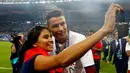 Cristiano Ronaldo berfoto dengan seorang fan seusai menjuarai Piala Eropa 2016 di Stade de France, Saint-Denis, Senin (11/7/2016) dini hari WIB. (Reuters/Michael Dalder)